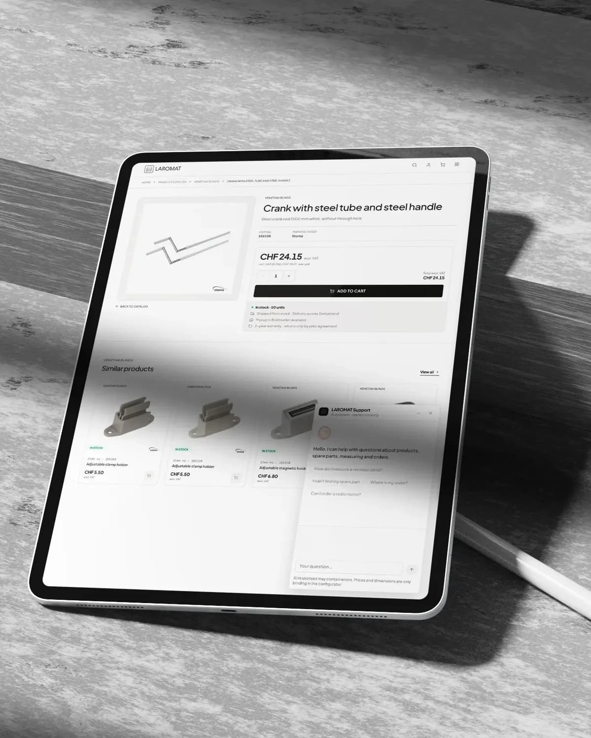 Ein Tablet mit Stift auf einem grauen Holztisch, darauf die Produktseite von Laromat für eine Kurbel mit Stahlrohr und Stahlgriff zu CHF 24.15, mit ähnlichen Produkten und dem Support-Chat