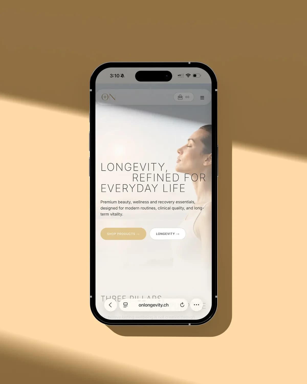 Ein Smartphone auf sandfarbenem Hintergrund in einem Streifen Sonnenlicht, darauf die Startseite von On Longevity mit der Zeile «Longevity, refined for everyday life»