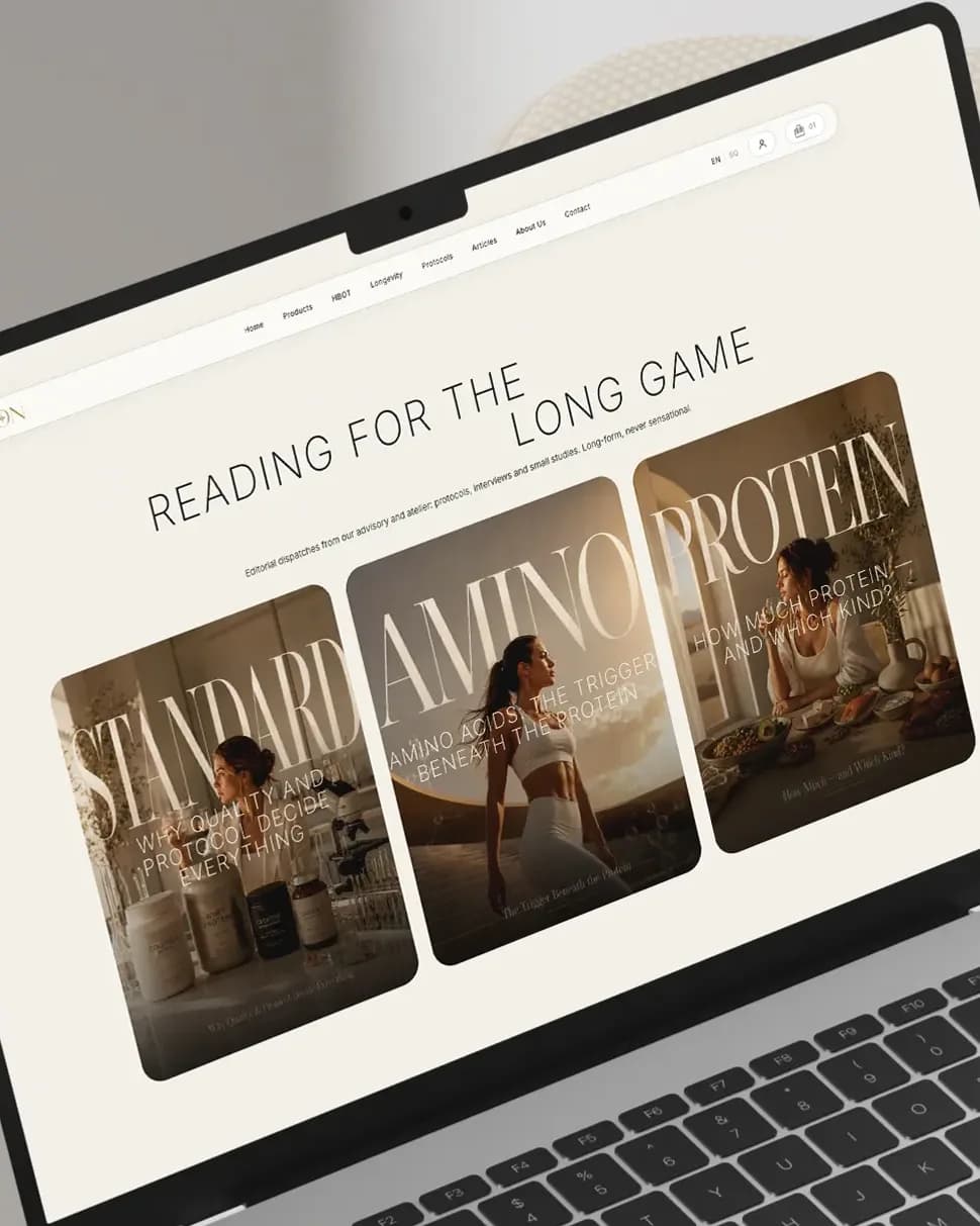 Ein Laptop neben einem cremefarbenen Sessel, darauf das Journal von On Longevity: «Reading for the long game» mit drei Artikelkacheln