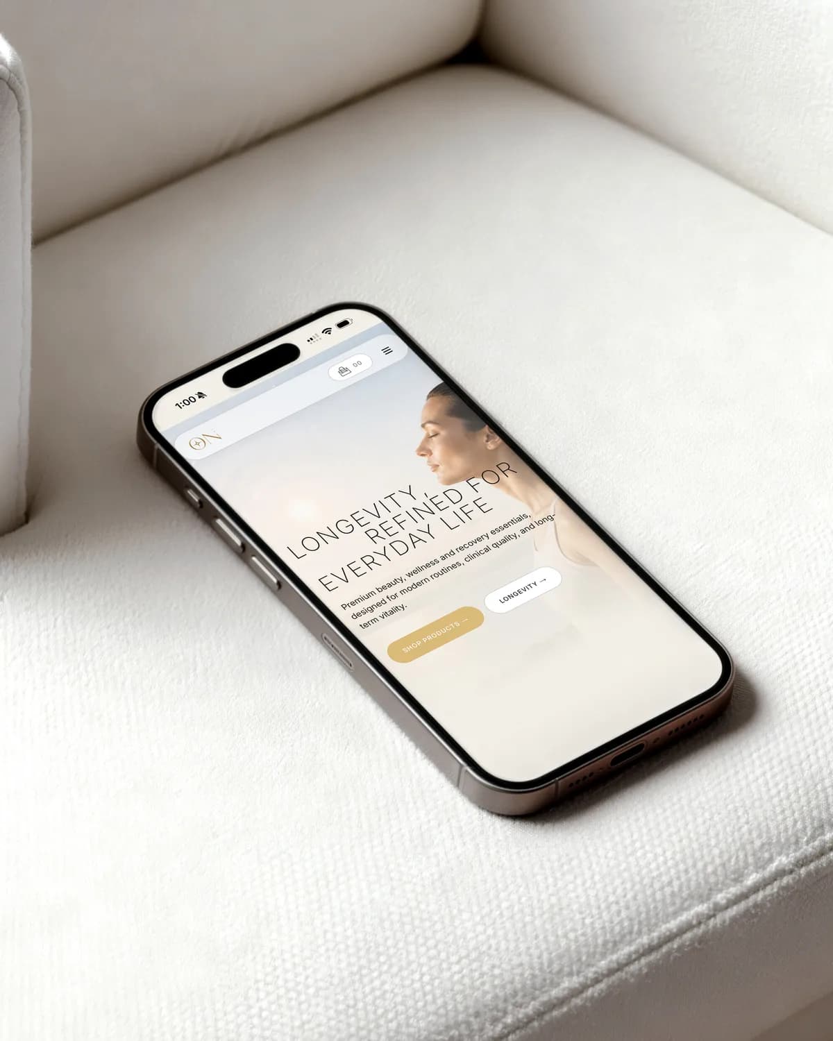 Ein Smartphone auf einem weissen Leinensessel mit der Startseite von On Longevity und der Zeile «Longevity, refined for everyday life»