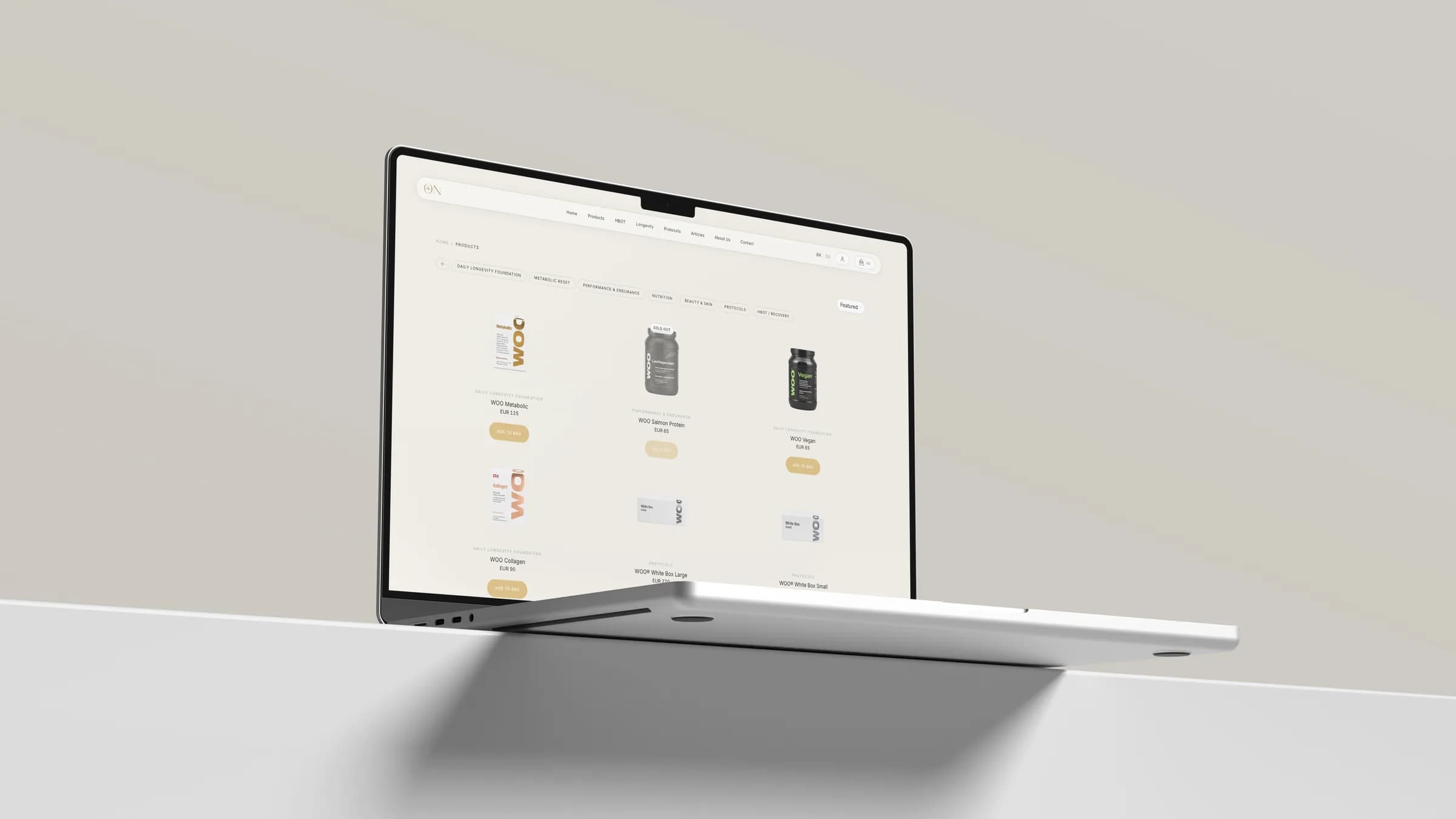 Ein Laptop am Rand eines weissen Simses vor einer warmgrauen Wand, darauf die Produktseite von On Longevity